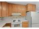 Kitchen features wood cabinets and a white refrigerator at 7350 Field St, Arvada, CO 80005
