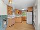 Traditional kitchen featuring wood cabinets, an island, and a white refrigerator at 7350 Field St, Arvada, CO 80005