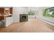Bright living room featuring a cozy fireplace, large windows, and unfinished wood floors at 7350 Field St, Arvada, CO 80005