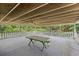 Spacious covered patio with a table and bench, offering a peaceful spot with views of the surrounding greenery at 7350 Field St, Arvada, CO 80005