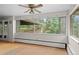 Bright sunroom with large windows offering views of the surrounding trees and outdoor balcony at 7350 Field St, Arvada, CO 80005