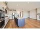 Bright kitchen with white cabinets, stainless steel appliances, and island with quartz countertop at 2978 Newfound Lake Rd, Berthoud, CO 80513