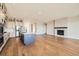 Open-concept living room with wood floors, fireplace, and a view of the kitchen island at 2978 Newfound Lake Rd, Berthoud, CO 80513