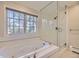 Relaxing bathroom features a soaking tub, separate shower, and large window for natural light at 2991 S Fillmore Way, Denver, CO 80210