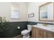 Stylish half-bathroom featuring wood-look floors, wainscoting and modern vanity with marble countertop at 26361 E 5Th Pl, Aurora, CO 80018