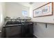 Well-lit laundry room featuring modern washer and dryer, shelving, and stylish decor at 26361 E 5Th Pl, Aurora, CO 80018
