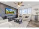 Bright living room featuring a decorative wall, plush seating, and large windows at 26361 E 5Th Pl, Aurora, CO 80018