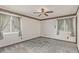 An empty bedroom with neutral carpeting, two windows with blinds, and decorative trim at 881 S Pearl St, Elizabeth, CO 80107