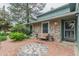 Charming home exterior with stone accents, cozy seating area, and a decorative brick patio at 881 S Pearl St, Elizabeth, CO 80107
