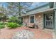 Charming home exterior with stone accents, cozy seating area, and a decorative brick patio at 881 S Pearl St, Elizabeth, CO 80107