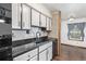 A kitchen view, showing sleek black countertops, white cabinets, and contrasting hardware at 881 S Pearl St, Elizabeth, CO 80107