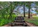 Stone steps lead to a private garden gate, surrounded by mature trees and manicured landscaping at 881 S Pearl St, Elizabeth, CO 80107