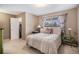 Bedroom with neutral walls, carpet, and an inviting bed near a window with patterned curtains at 12661 W Alameda Dr, Lakewood, CO 80228