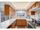 A kitchen showcasing wood cabinets, stainless steel appliances, and a view to the fenced backyard at 12661 W Alameda Dr, Lakewood, CO 80228