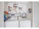 A laundry room with a side-by-side washer and dryer and overhead cabinets for storage at 12661 W Alameda Dr, Lakewood, CO 80228