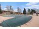 Outdoor pool, currently covered, surrounded by lush trees and well-kept residential buildings at 12661 W Alameda Dr, Lakewood, CO 80228