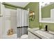Bathroom with shower, granite countertop sink, and green painted walls at 915 S Mckinley Ave, Fort Lupton, CO 80621