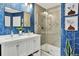 Stylish bathroom with blue patterned wallpaper, double vanity, and glass-enclosed shower at 915 S Mckinley Ave, Fort Lupton, CO 80621