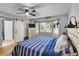 Bright bedroom with a sliding barn door, ceiling fan, and a view of the outdoors at 915 S Mckinley Ave, Fort Lupton, CO 80621