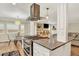 Stylish kitchen with stainless steel range hood, cooktop and granite countertop overlooking the living room at 915 S Mckinley Ave, Fort Lupton, CO 80621