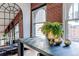 Dining room featuring exposed brick, arched windows, city views, and modern decor at 1555 California St # 605, Denver, CO 80202