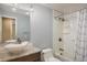 Bright bathroom features a granite-topped vanity with vessel sink, tub/shower combo, and modern light fixture at 7210 Otis Ct, Arvada, CO 80003
