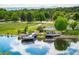 Picturesque park view showcasing a tranquil pond, docks, and playground amid lush greenery at 7210 Otis Ct, Arvada, CO 80003
