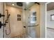 Walk-in shower featuring sleek glass doors and multiple shower heads at 7210 Otis Ct, Arvada, CO 80003