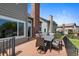 View of a deck with outdoor dining table set with mature trees and blue skies above at 42 Blue Sage, Littleton, CO 80127