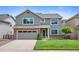 Inviting two-story home featuring a brick facade, well-manicured lawn, and attached garage at 42 Blue Sage, Littleton, CO 80127