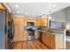 Functional kitchen featuring stainless steel appliances, wood cabinets, and a view into the living area at 42 Blue Sage, Littleton, CO 80127