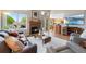 Cozy living room featuring a fireplace, wood floors, a sliding glass door, and an open view of the kitchen at 42 Blue Sage, Littleton, CO 80127
