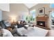 Bright living room with vaulted ceilings, a brick fireplace, large windows, and comfortable seating at 42 Blue Sage, Littleton, CO 80127