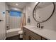 Stylish bathroom featuring decorative tilework around the tub and shower and a sleek oval mirror over the vanity at 375 Marshall Rd, Superior, CO 80027