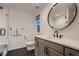 Modern bathroom featuring a glass-enclosed shower, a sleek vanity with a round mirror, and dark hexagonal floor tiles at 375 Marshall Rd, Superior, CO 80027