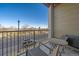 Relaxing balcony features outdoor furniture, black metal railings, and pleasant neighborhood views on a bright, sunny day at 420 E Fremont Pl # 203, Centennial, CO 80122