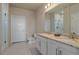 Bright bathroom with double sinks, granite countertops, a modern toilet, and a glass-enclosed shower at 420 E Fremont Pl # 203, Centennial, CO 80122