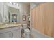 Clean bathroom with a vanity, toilet, shower with peach curtain and practical shelving at 420 E Fremont Pl # 203, Centennial, CO 80122