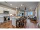 Modern kitchen with white cabinets, stainless steel appliances, and a breakfast bar overlooking the living area at 420 E Fremont Pl # 203, Centennial, CO 80122