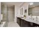 Elegant bathroom featuring dual vanities with marble countertops and a frameless glass shower at 3434 S Race St, Englewood, CO 80113