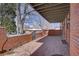 Spacious brick patio with partial snow coverage, featuring an iron gate and covered area at 3434 S Race St, Englewood, CO 80113