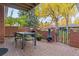 Outdoor patio featuring brick flooring, a table and chairs, grill, and a decorative iron gate at 3434 S Race St, Englewood, CO 80113