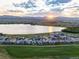 This aerial view shows the lake, mountains, green space, and homes in the community at 2932 Heron Lakes Pkwy, Berthoud, CO 80513