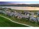 Dusk aerial view of the community with lake, mountain views, and manicured lawns at 2932 Heron Lakes Pkwy, Berthoud, CO 80513