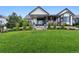 Expansive backyard and covered patio with lush lawn and manicured landscaping at 2932 Heron Lakes Pkwy, Berthoud, CO 80513