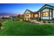 Lush backyard with a manicured lawn, patio seating, and mature trees, providing a serene outdoor retreat at 2932 Heron Lakes Pkwy, Berthoud, CO 80513