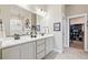 Bathroom featuring double sinks with modern fixtures, and an entrance to a walk-in closet at 2932 Heron Lakes Pkwy, Berthoud, CO 80513
