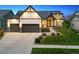 Beautiful home with a well-manicured lawn, stone accents, and a three-car garage at 2932 Heron Lakes Pkwy, Berthoud, CO 80513
