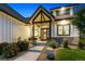 Inviting front porch with stone accents, a well-maintained lawn, and decorative planters at 2932 Heron Lakes Pkwy, Berthoud, CO 80513