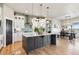 Spacious kitchen with a gray island, white cabinets, and stainless steel appliances and a dining space at 2932 Heron Lakes Pkwy, Berthoud, CO 80513